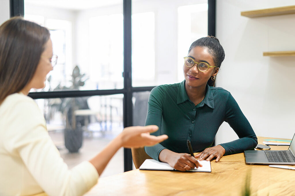 Unterhaltung zweier Frauen im Büro als Symbolbild für das Coaching für Berufserfahrene