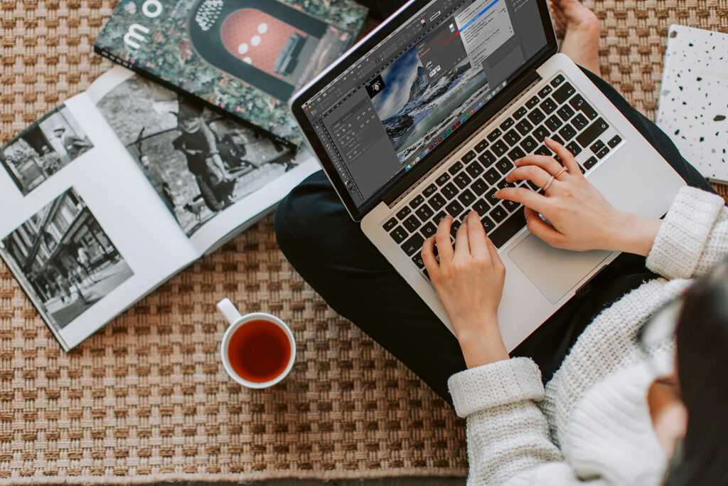 Junge Person arbeitet am Grafiktablet mit Adobe-Software – Photoshop, Illustrator und InDesign im Einsatz