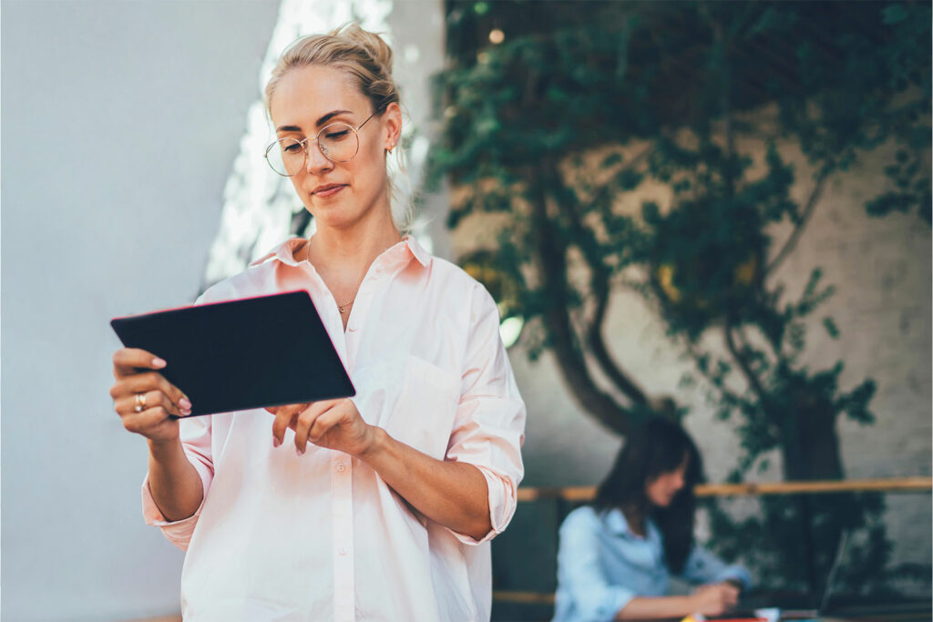 Social-Media-Grundlagen – Onlinekurs der Weiterbildungsagentur (WBA) Junge Frau nutzt Tablet für Social-Media-Marketing – Einstieg in digitale Kommunikation